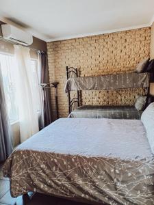 1 dormitorio con 1 cama con edredón marrón en Ambiente Budget Accommodation, en Upington