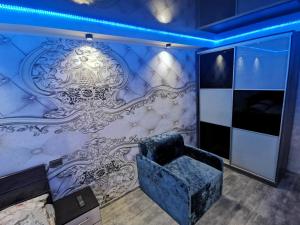 ザポリージャにあるNew Luxury apartment 2022 with jacuzzi on Mayakovskogo 16の椅子と壁画のある部屋