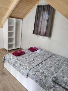 a bed in a room with red pillows on it at Guest House Koba in Batumi