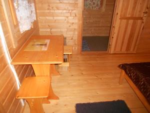 
a wooden table in a room with a wooden floor at Artur´s Eaterie and Holiday home in Viitna
