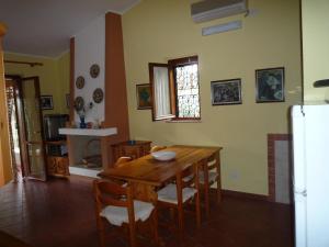 une salle à manger avec une table et des chaises en bois dans l'établissement Villetta Sunrise 21, à Costa Rei 48 autres photos