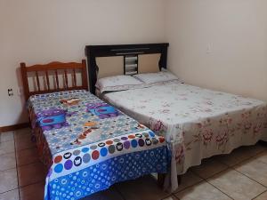 two beds sitting next to each other in a bedroom at Apartamento Confortável in Marechal Floriano