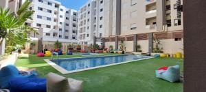 Un patio de apartamentos con piscina y algunos edificios. en Design & luxury apartment with sea view in Mrezga Hammamet, en Nabeul