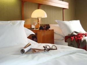 a pair of glasses on a bed with a lamp at Residence The Catalogne in Font-Romeu