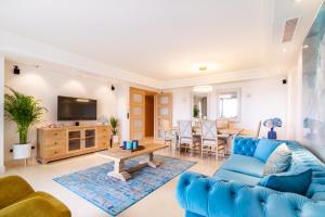 een woonkamer met een blauwe bank en een tafel bij MARBELLA BANUS SUITES - Golden Mile Jardines del Príncipe Suite Apartment in Marbella