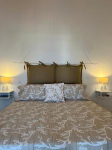 a bedroom with a large bed with two lamps at Bottari Rooms Panarea in Panarea
