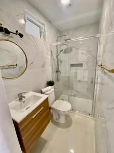 a bathroom with a shower and a toilet and a sink at Casinha da Patricia in Nazaré +24 photos