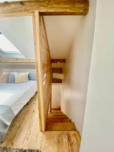 a small attic bedroom with a bed and a staircase at Casinha da Patricia in Nazaré
