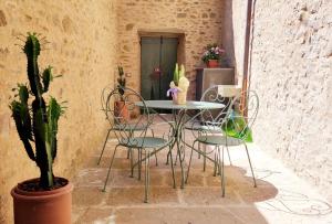 a patio with a table and chairs and a plant at Casa Primo in Cortona