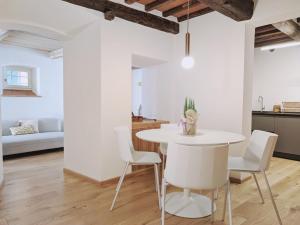 eine Küche und ein Esszimmer mit einem weißen Tisch und Stühlen in der Unterkunft Casa Primo in Cortona