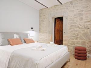 1 Schlafzimmer mit 2 Betten und einer Steinmauer in der Unterkunft Casa Primo in Cortona