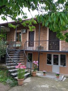 un edificio con una escalera y flores delante de él en Elegant Hotel, en Kutaisi