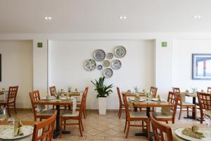 a dining room with tables and chairs and plates on the wall at Best Western Hotel Martello in Lampedusa