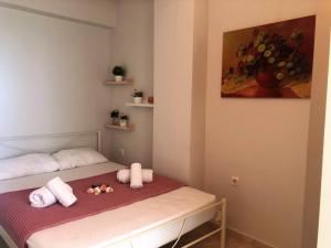 a small bedroom with a bed with towels on it at Pink Rose Apartment in Néa Péramos