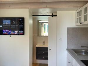 kuchnia z białymi szafkami i zlewem w obiekcie La petite maison d’Orphée w mieście Marmagne