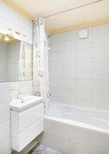 La salle de bains blanche est pourvue d'une baignoire et d'un lavabo. dans l'établissement Ona`s apartment in City Center with private parking, à Kaunas