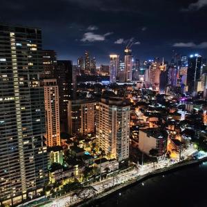 a city lit up at night with a city at Posada De Michi - Acqua Private Residences in Manila