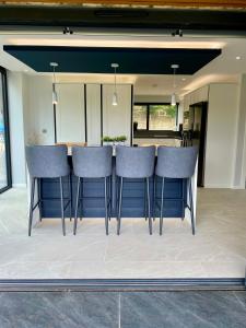 a kitchen with blue bar stools in a room at Stunning modern home set in beautiful grounds. in Bath