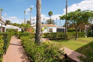 una casa con palmeras y una pasarela en Las Vegas Golf 316 en Las Palmas de Gran Canaria