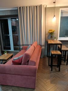 un soggiorno con divano viola e tavoli di Квартира бизнес -класса в ста метрах от городского парка a Petropavlovsk