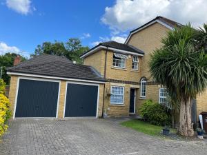 a house with two garage doors on a driveway at SleepNeat in Ascot