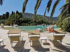 a pool with chairs and a swimming pool at Tartheshotel in Guspini
