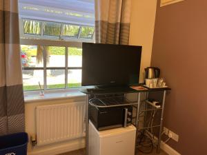 a computer monitor on a stand in front of a window at SleepNeat in Ascot