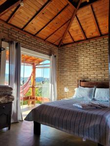 una camera da letto con un letto grande e una grande finestra di Chalés Bela Vista a São Thomé das Letras Altre 91 foto