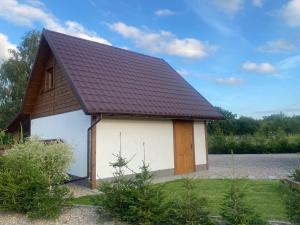 mały dom z brązowym dachem w obiekcie MAZUR 35 w mieście Szyldak