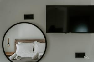 a mirror in a room with a bed and a tv at Elaionas Estate Perdika in Perdika