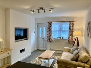 a living room with a couch and a tv at Modern 2 Bedroom Ground Floor Apartment with Parking Ripon City Centre in Ripon