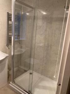 a shower with a glass door in a bathroom at Modern 2 Bedroom Ground Floor Apartment with Parking Ripon City Centre in Ripon