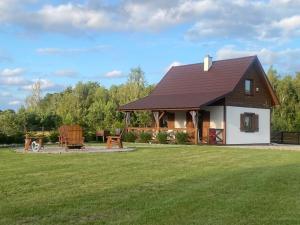 una casa con un gran patio con un campo verde en MAZUR 84, en Szyldak