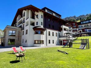 a large building with a lawn chair in front of it at Superior Hotel Panorama in Obertauern