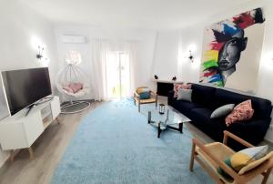 un salon avec un canapé noir et une télévision dans l'établissement Alojamento local "CASA BRANCA", à Albufeira