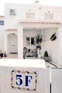 une maison blanche avec un panneau qui dans l'établissement Alojamento local "CASA BRANCA", à Albufeira