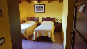 アグリジェントにあるB&B A Robba de Pupiの黄色い壁の客室内のベッド2台