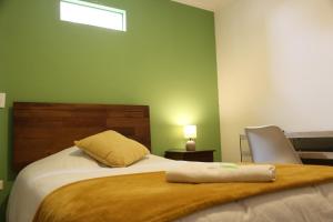 a bedroom with a bed with a pillow and a chair at Aparthotel Don Alonso in Antofagasta