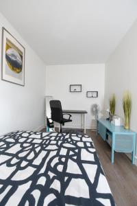 a bedroom with a bed and a desk and a chair at Superbe 2 pièces - proche de Paris in Villeneuve-la-Garenne