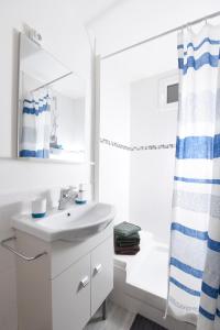 ein weißes Bad mit einem Waschbecken und einem Duschvorhang in der Unterkunft Superbe 2 pièces - proche de Paris in Villeneuve-la-Garenne