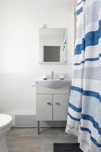 a white bathroom with a sink and a shower curtain at Superbe 2 pièces - proche de Paris in Villeneuve-la-Garenne