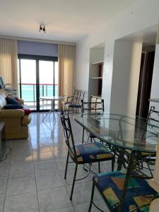 een woonkamer met een glazen tafel en stoelen bij Apartamento Martin de Sá in Caraguatatuba