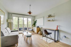 una sala de estar con un sofá y una mesa en Le Saint Cyr, en Saint-Cyr-lʼÉcole