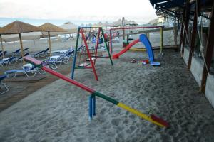un parque infantil en la arena de la playa en Studios Paradise, en Kalamaki