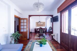 a living room with a couch and a table at Luminoso apartamento reformado en villa termal in Cuntis