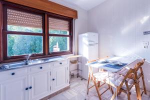 a kitchen with a sink and a table with chairs at Luminoso apartamento reformado en villa termal in Cuntis