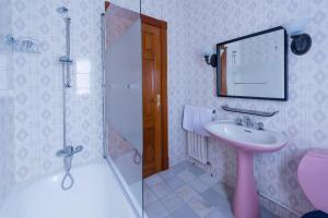 a bathroom with a pink sink and a shower at Luminoso apartamento reformado en villa termal in Cuntis