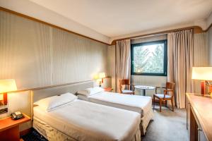 pokój hotelowy z dwoma łóżkami i oknem w obiekcie Hotel Della Rotonda w mieście Saronno +37 zdjęć