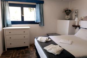 a bedroom with a bed and a dresser and a window at Blue Vista Ikaria in Arethousa