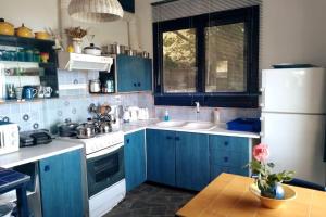 a kitchen with blue cabinets and a white refrigerator at Blue Vista Ikaria in Arethousa